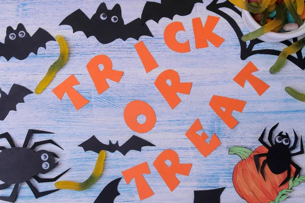 The concept of the holiday of Halloween. bats and sweets on a blue background with an inscription trick or treat top view