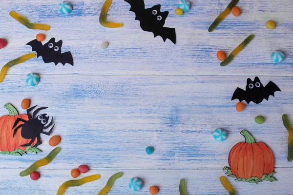 The concept of the holiday of Halloween. bats and sweets on a blue background with an inscription trick or treat top view