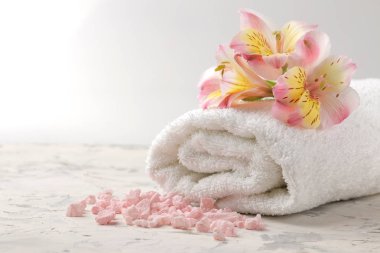 Bir havlu, deniz tuzu ve çiçekler ile Spa kompozisyon. Spa kavramı. hafif bir arka plan üzerinde.