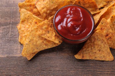 Cips. Cips ve kırmızı sos kahverengi ahşap bir masa üzerinde bir sürü. sağlıksız yiyecek