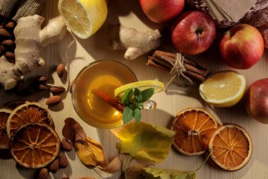 Sıcak çay, meyve ve doğal ahşap bir masa üzerinde sarı yapraklar ile sonbahar kompozisyon. yukarıdan görüntülemek