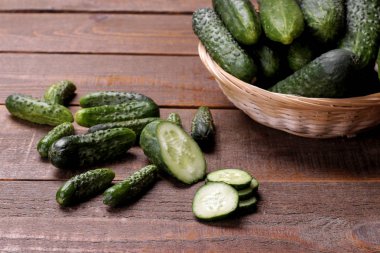 Bir sepet ve kahverengi ahşap bir masa üzerinde salatalık dilim taze yeşil salatalık. sebze