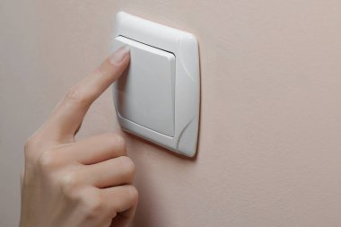 Elektrik tasarrufu kavramı. Kız odasında ışıkları kapatır. yakın çekim