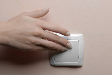 Elektrik tasarrufu kavramı. Kız odasında ışıkları kapatır. yakın çekim