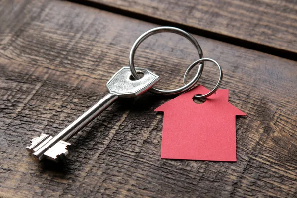 买房的概念 钥匙与钥匙串房子在棕色木背景特写镜头 — 图库照片