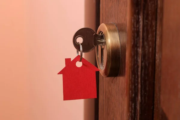 买房的概念 钥匙与钥匙串房子在门锁特写 — 图库照片