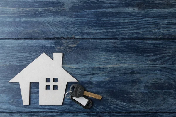 买房的概念 装饰小屋和房子钥匙在蓝色木背景与一个地方为题字 顶视图 — 图库照片