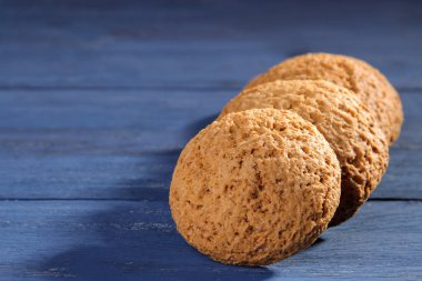 bir yığın mavi ahşap bir masa üzerinde Kazıklı yulaf ezmeli kurabiye. fırında. lezzetli planı