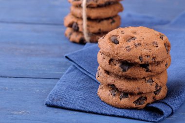 güzel mavi ahşap masa peçeteye üzerine yığılmış çikolata kurabiye. fırında. nefis
