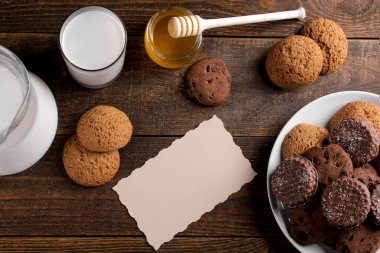 Bal ve kahverengi ahşap bir masa üzerinde süt ile farklı lezzetli tatlılar. yukarıdan görüntülemek