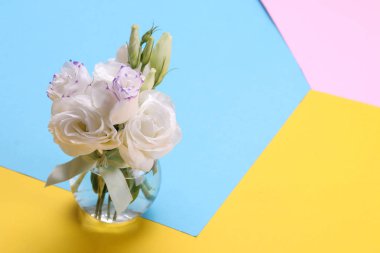 Güzel beyaz çiçekler. Bir buket bir vazo içinde eustoma. renkli parlak kağıt arka plan üzerinde.