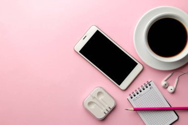 Beyaz smartphone ve bir fincan kahve ve ofis malzemeleri bir parlak pembe. yukarıdan görüntülemek
