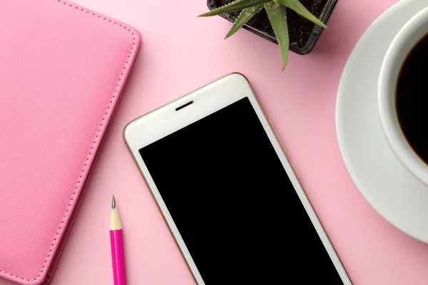 Ein Weißes Smartphone Eine Tasse Kaffee Und Ein Pinkfarbener Notizblock — Stockfoto