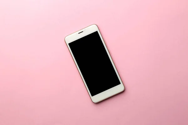 Beyaz smartphone bir parlak pembe bir arka plan üzerinde. yukarıdan görüntülemek