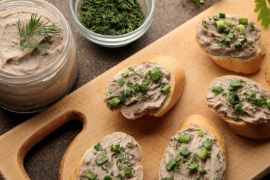 Taze ev yapımı tavuk karaciğer pate ekmek üzerinde karanlık bir arka plan üzerinde yeşillikleri ile. yukarıdan görüntülemek