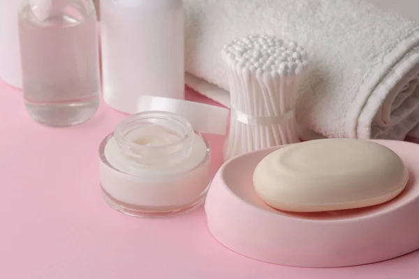 Body and skin care products in white packaging on a pink delicate background. Personal hygiene products.
