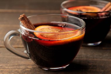 Tarçın ve turuncu renkte cam bardak koyu bir arka plan karşı sıcak mulled şarap. Noel. Yeni yıl.