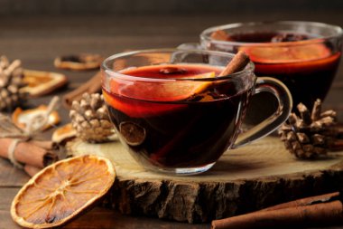 Tarçın ve turuncu renkte cam bardak koyu bir arka plan karşı sıcak mulled şarap. Noel. Yeni yıl.