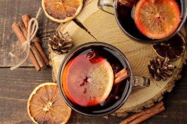 Tarçın ve turuncu renkte cam bardak koyu bir arka plan karşı sıcak mulled şarap. Noel. Yeni yıl. yukarıdan görüntülemek