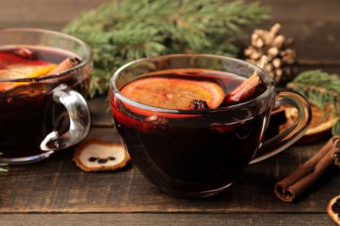 Tarçın ile mulled şarap ve turuncu cam bardak ve Noel süsleri karanlık bir arka plan üzerinde sıcak. Noel. Yeni yıl.