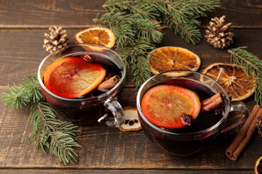Tarçın ile mulled şarap ve turuncu cam bardak ve Noel süsleri karanlık bir arka plan üzerinde sıcak. Noel. Yeni yıl.