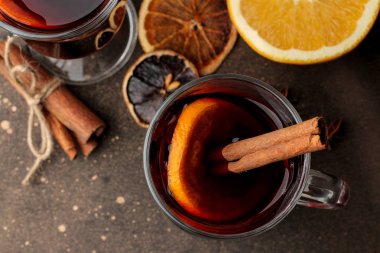 Tarçın ve turuncu renkte koyu arka plan cam bardak yakın çekim sıcak mulled şarap. Yukarıdan görüntüleyin. Noel. Yeni yıl.