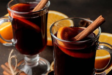 Tarçın ve turuncu renkte koyu arka plan cam bardak yakın çekim sıcak mulled şarap. Noel. Yeni yıl.