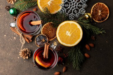 Tarçın ile mulled şarap ve turuncu cam bardak ve Noel süsleri karanlık bir arka plan üzerinde sıcak. Yukarıdan görüntüleyin. Noel. Yeni yıl.