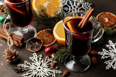 Tarçın ile mulled şarap ve turuncu cam bardak ve Noel süsleri karanlık bir arka plan üzerinde sıcak. Noel. Yeni yıl.