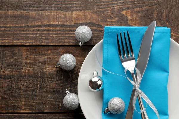 圣诞餐桌设置 用蓝色餐巾的刀 叉子和盘子 在一张棕色的木桌上顶部的视野与空间的题词 新的一年 — 图库照片