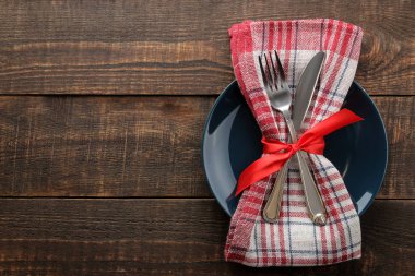 Noel tablo ayarı. Bıçak, çatal, halka ve yeni yıl süslemeleri ile plaka. kahverengi ahşap bir masa üzerinde. üstten görünüm ile bir yazıt için yer. Yeni yıl. tatil