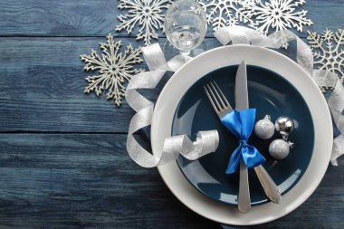 Noel tablo ayarı. Bıçak, çatal, halka ve yeni yıl süslemeleri ile plaka. mavi ahşap bir masa üzerinde. üstten görünüm ile bir yazıt için yer. Yeni yıl. tatil
