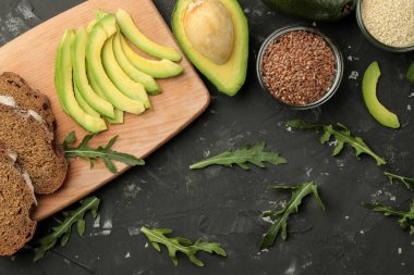 Avokado, peynir, ekmek. avokado sandviç yapmak için malzemeler. Karanlık bir arka plan üzerinde. yukarıdan görüntülemek.