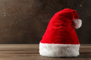 Koyu kahverengi arka plan üzerinde kırmızı Santa Claus şapka duran. metin için yer ile. Noel. Yeni yıl.