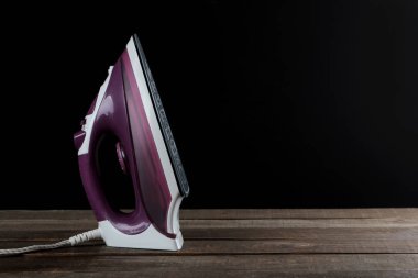 Siyah bir arka plan üzerinde Lila demir. elbise Ütü. eşyaları elektrikli ev aletleri. metin için ile yer.