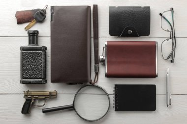 Erkek aksesuarlar. erkek tarzı. Flask, iş kart sahibi, Büyüteç, defter, parfüm, anahtarları, Gözlük, m-cüzdan Beyaz ahşap zemin üzerinde. düz lay.