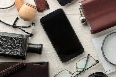 Erkek aksesuarlar. Erkek tarzı. Smartphone, kravat, anahtarları, cüzdanı, iş kart sahibi, şişesi, Gözlük, kalem ve defter Beyaz ahşap zemin üzerinde. düz lay. 