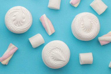 Tatlı beyaz şekerlemeler ve parlak trendy mavi zemin üzerine küçük Marshmallow arka plan. Tatlılar. tatlı. yukarıdan görüntülemek