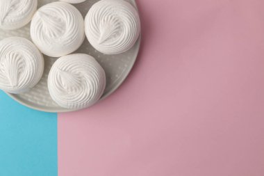 Tatlı beyaz hatmi bir parlak şık mavi ve pembe arka plan üzerinde bir tabakta. Tatlılar. tatlı. metin için yer ile üstten görünüm