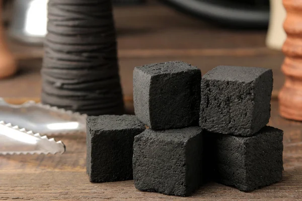 coconut coals for hookah close-up on a brown wooden table and accessories for making hookah. hookah accessories