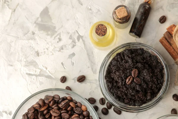 homemade coffee scrub in a jar for the face and body, and various ingredients for making scrub on a light background. spa. cosmetics. care cosmetics. top view with space for text
