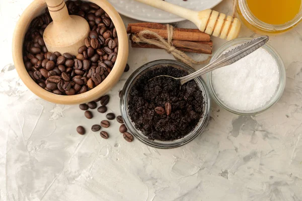 homemade coffee scrub in a jar for the face and body, and various ingredients for making scrub on a light background. spa. cosmetics. care cosmetics. view from above