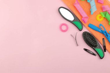 Çeşitli saç aksesuarları, curlers, taraklar, şeklinde saç tokası ve lastikleri. bir parlak pembe. metin için yer ile üstten görünüm