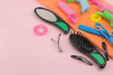 Çeşitli saç aksesuarları, curlers, taraklar, şeklinde saç tokası ve lastikleri. bir parlak pembe. metin için yer ile üstten görünüm