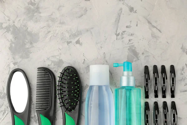 hair cosmetics and hair accessories, hairbrushes and barrettes. on a light concrete background hair care products. top view with space for text