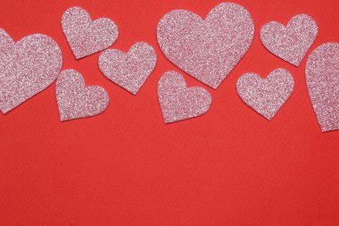 Parlak kırmızı bir arka plan üzerinde pembe kalpler. çerçeve kalplerin, metin için yer ile üstten görünüm