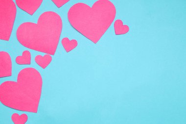 Parlak mavi bir arka plan üzerinde pembe kalpler. çerçeve kalplerin, metin için yer ile üstten görünüm