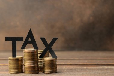 Word vergi ve kahverengi ahşap arka plan üzerinde sikke yığını. metin için ile yer