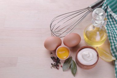 Mayonez bir ahşap kase ve bir doğal ahşap arka plan üzerine mayonez yapmak için malzemeler. beyaz sos. metin için ile yer