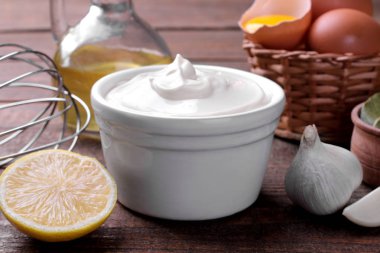 Mayonez beyaz bir kase ve bir kahverengi ahşap arka plan üzerine mayonez yapmak için malzemeler. beyaz sos. yakın çekim